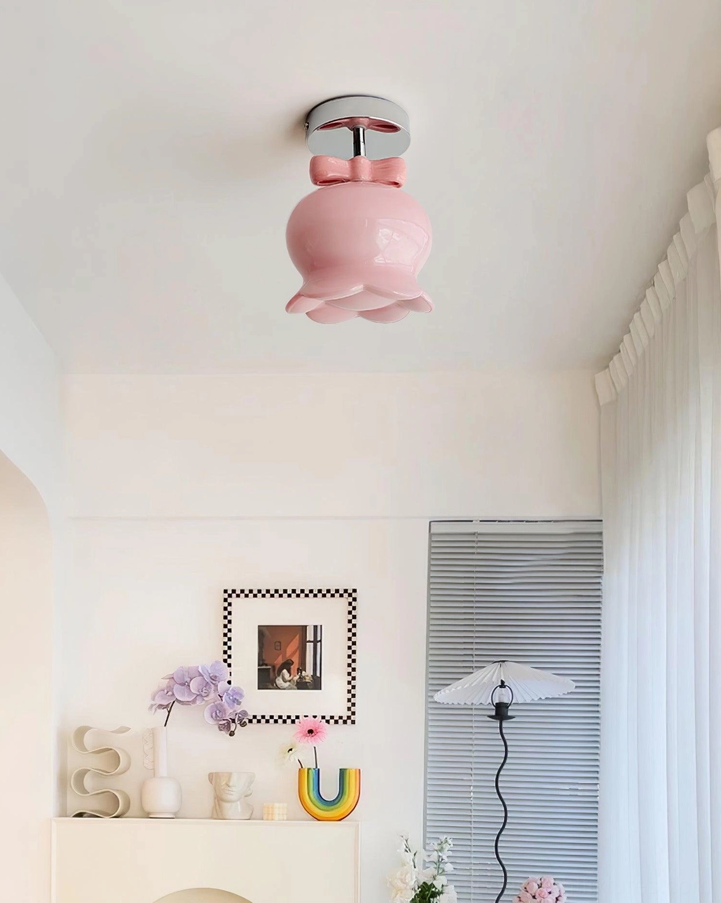Installed pink bell ceiling light fixture in bright residential console area with chrome ceiling mount and pastel home decor aesthetic