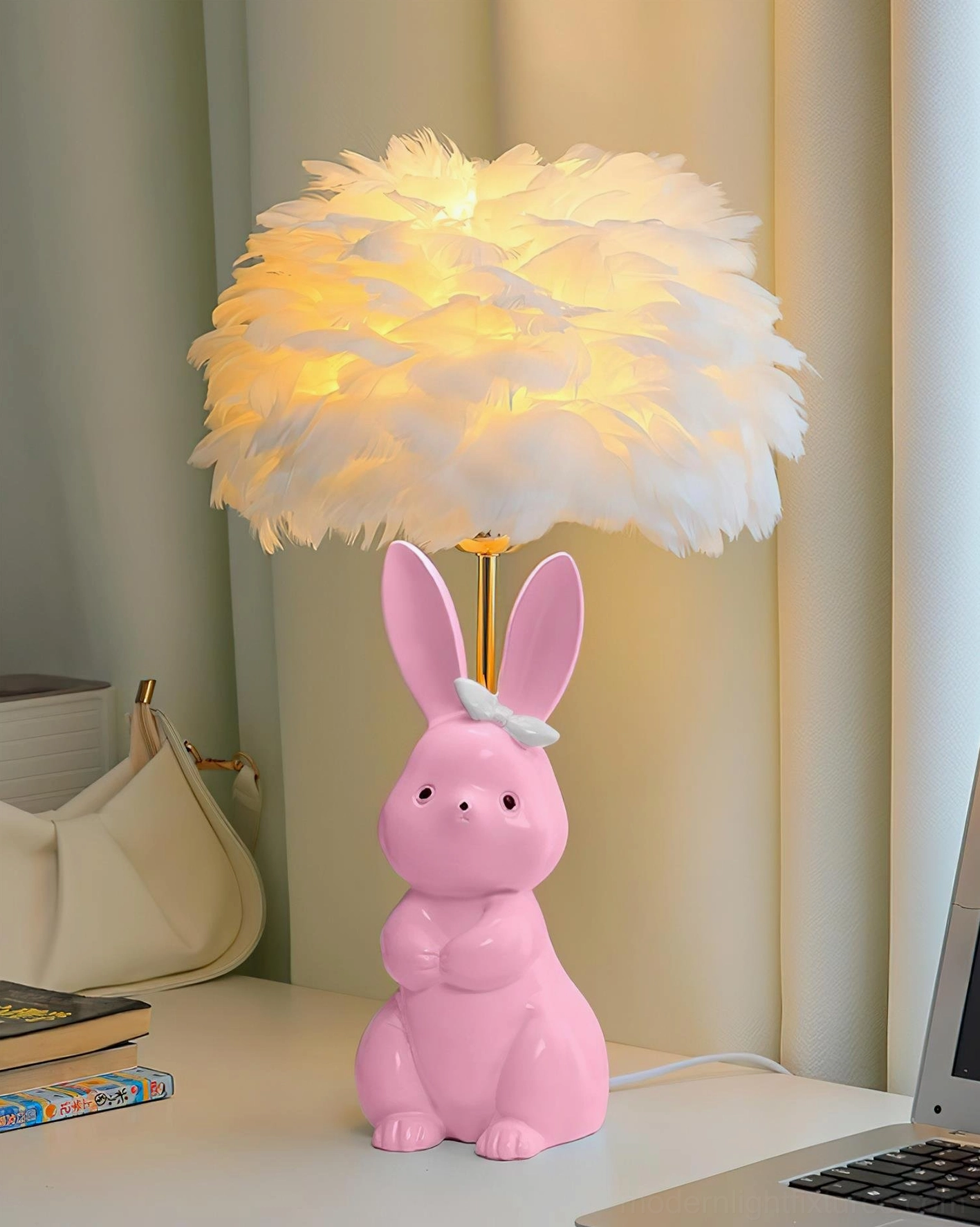 Pink ceramic rabbit base table lamp with white feather shade and white bow on home workspace