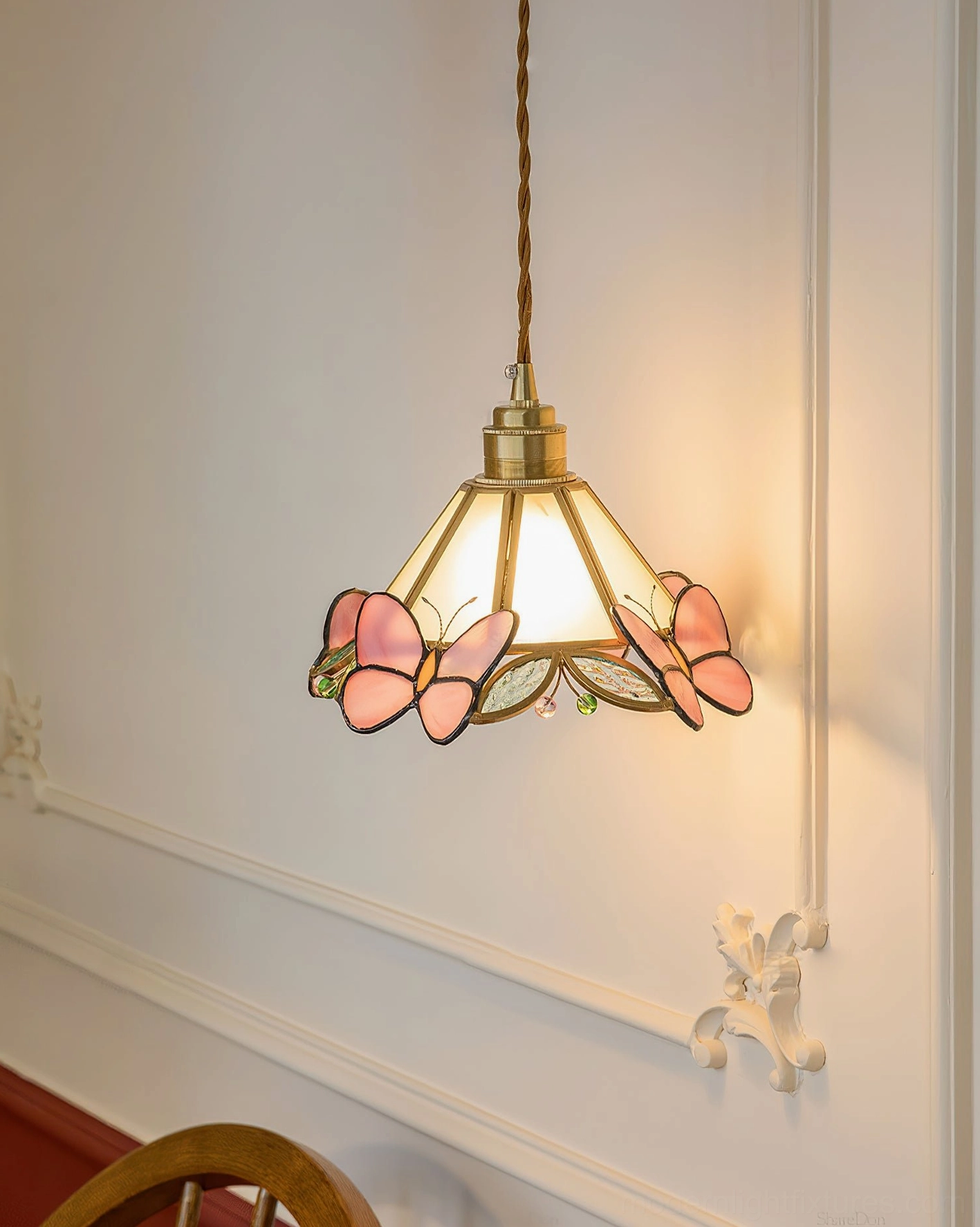 Compact Pink Butterfly Tiffany pendant light in vintage paneled wall setting with warm ambient lighting