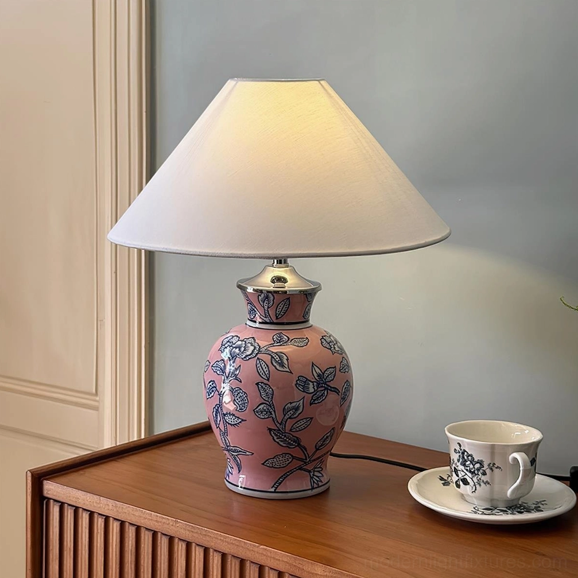 Pink ceramic floral table lamp with blue flower motifs, fabric shade for soft light diffusion and ambiance
