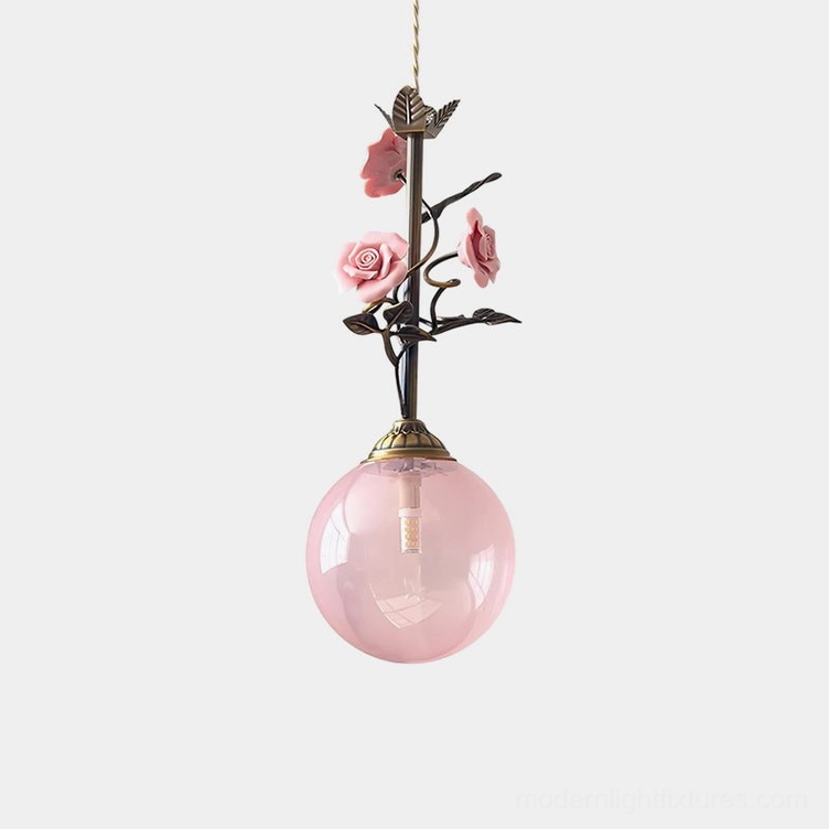 Pink floral pendant light with hand-crafted rose details and frosted glass globe, studio product photography