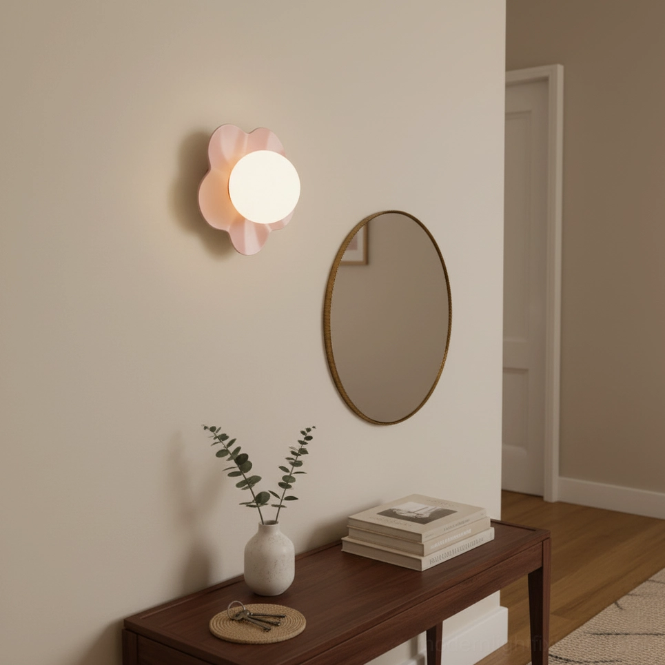 Pink flower wall lamp installed beside oval mirror and wooden side table in entryway
