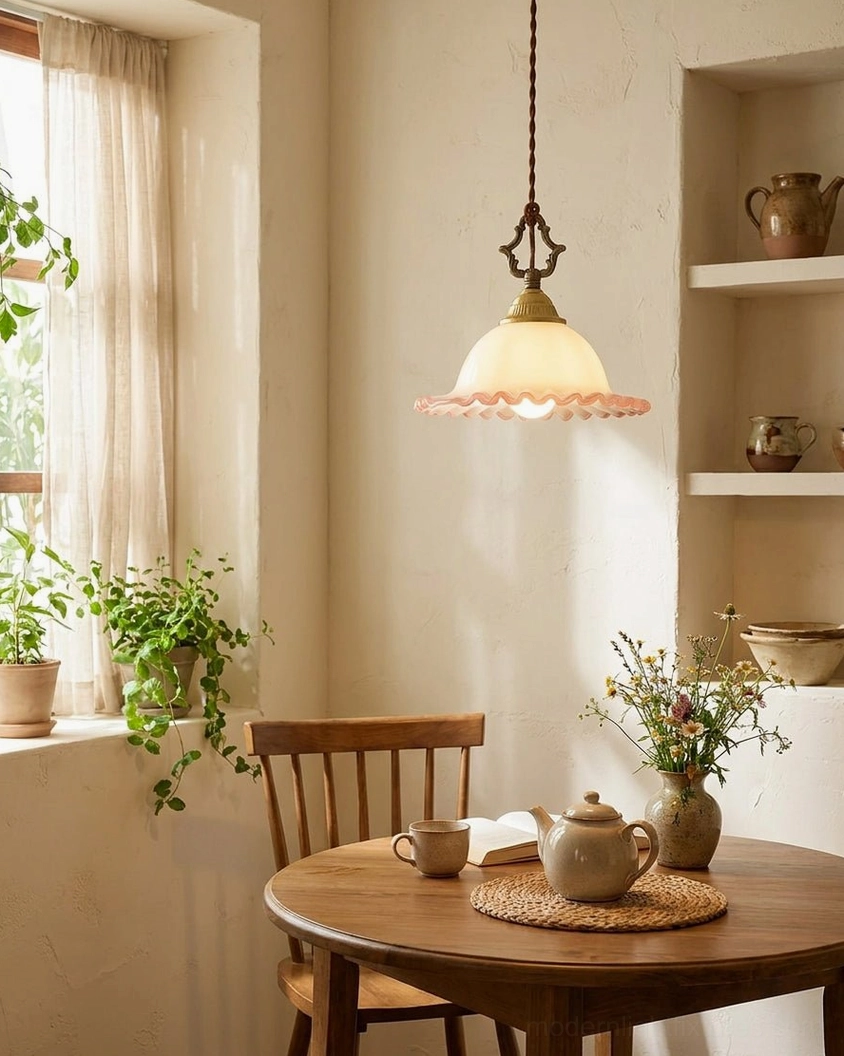 Small pink glass pendant above wooden dining table - cottagecore breakfast nook lighting fixture