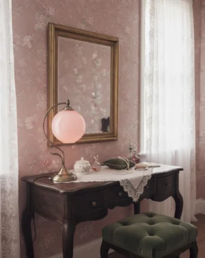 Pink globe table lamp on vintage vanity desk with damask wallpaper and gold mirror, romantic bedroom lighting setup