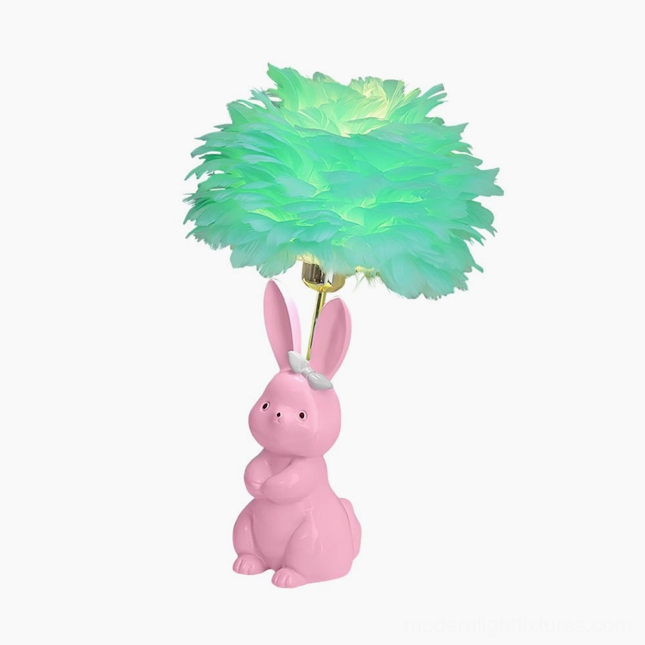 Pink and green feather pastel bunny table lamp creating warm glow in bedroom setting