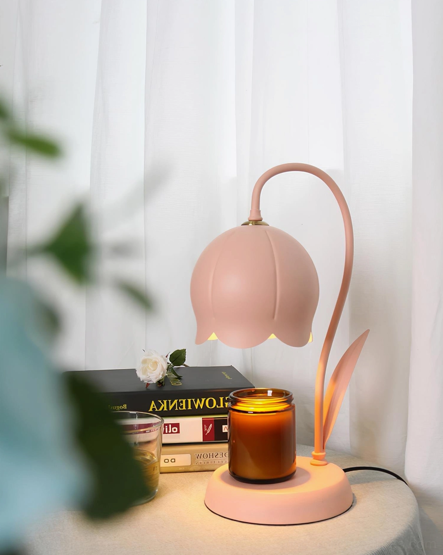 Pink lily flower candle warmer lamp three-quarter side view on desk with books and small decorative items