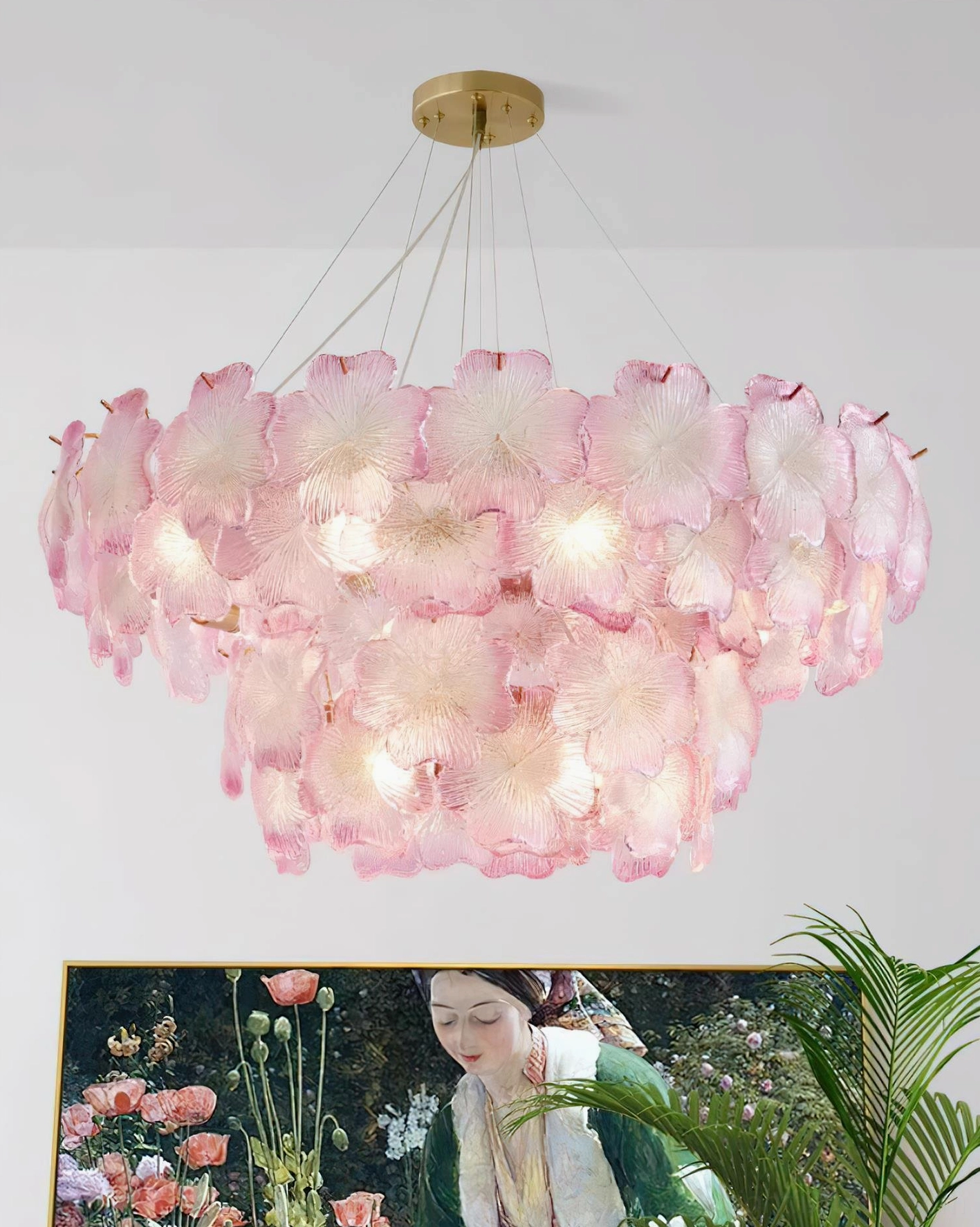 Pink Mika botanical chandelier illuminated in modern living room with warm ambient lighting and green plant decor
