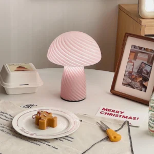 Pink ribbed swirl mushroom glass table lamp three-quarter view on festive Christmas dining table