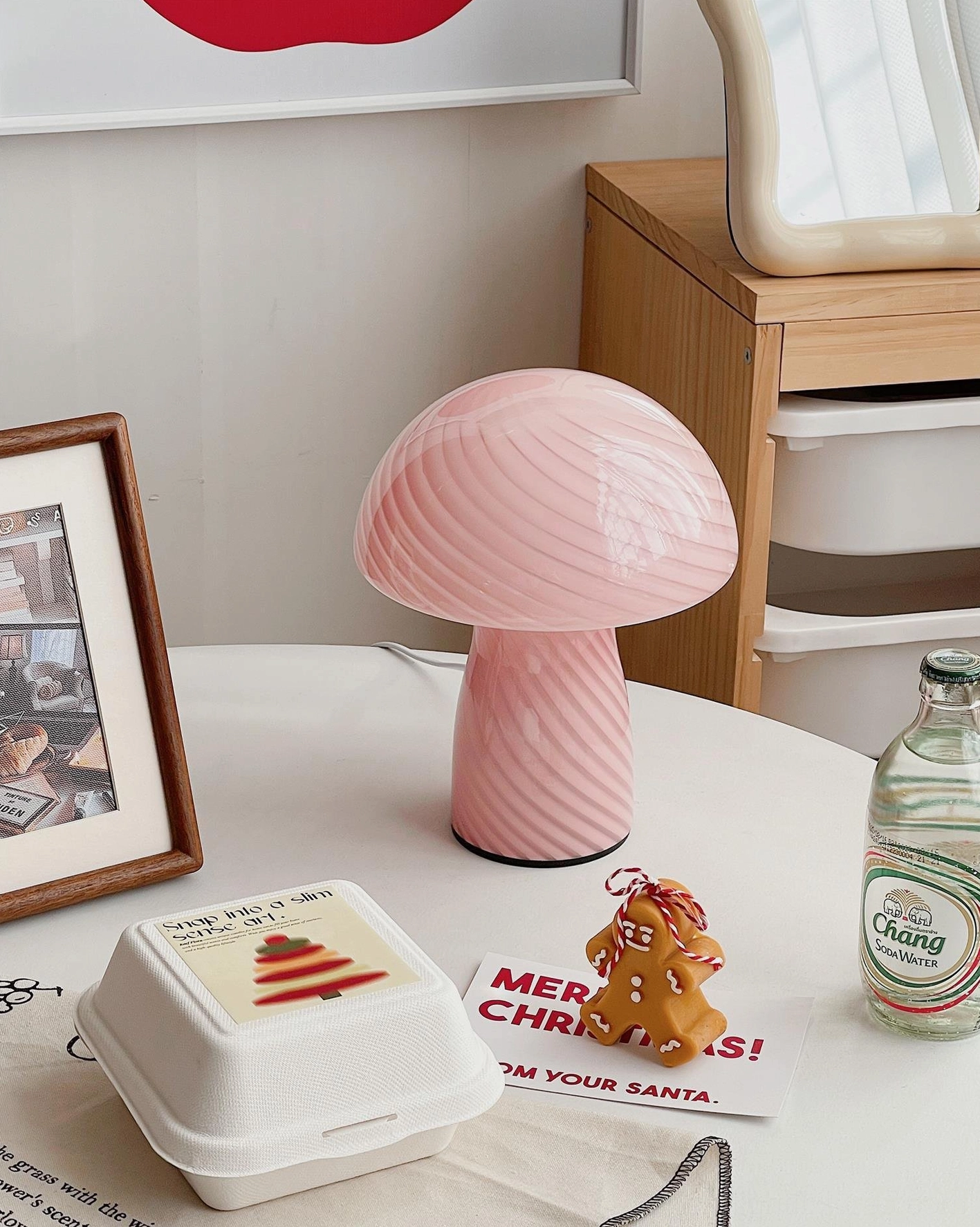 Pink mushroom glass table lamp low-angle view on residential home office desk with gingerbread decoration