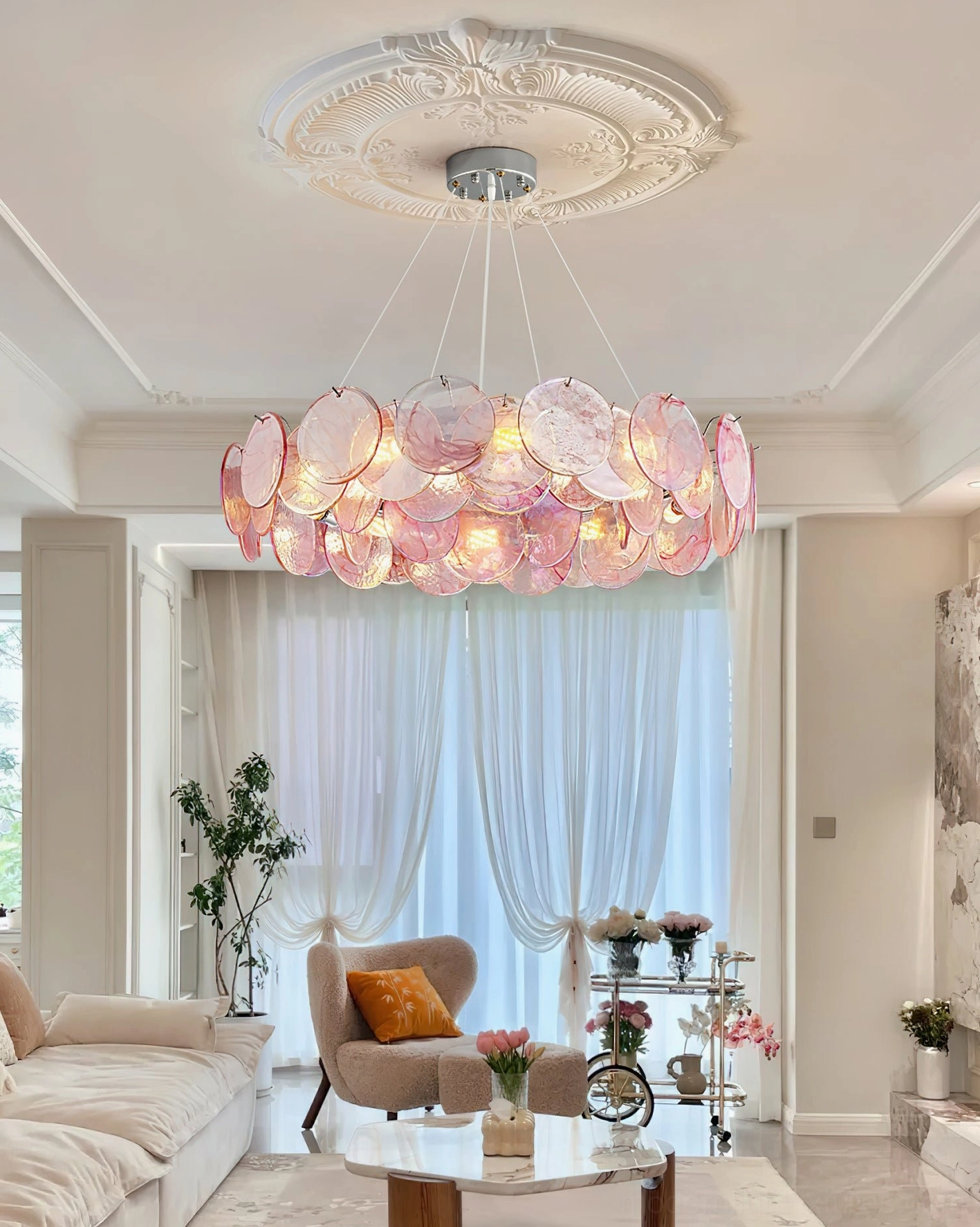 Pink cascading pendant chandelier mounted on ceiling plate in cozy modern living room with sofa soft warm lighting
