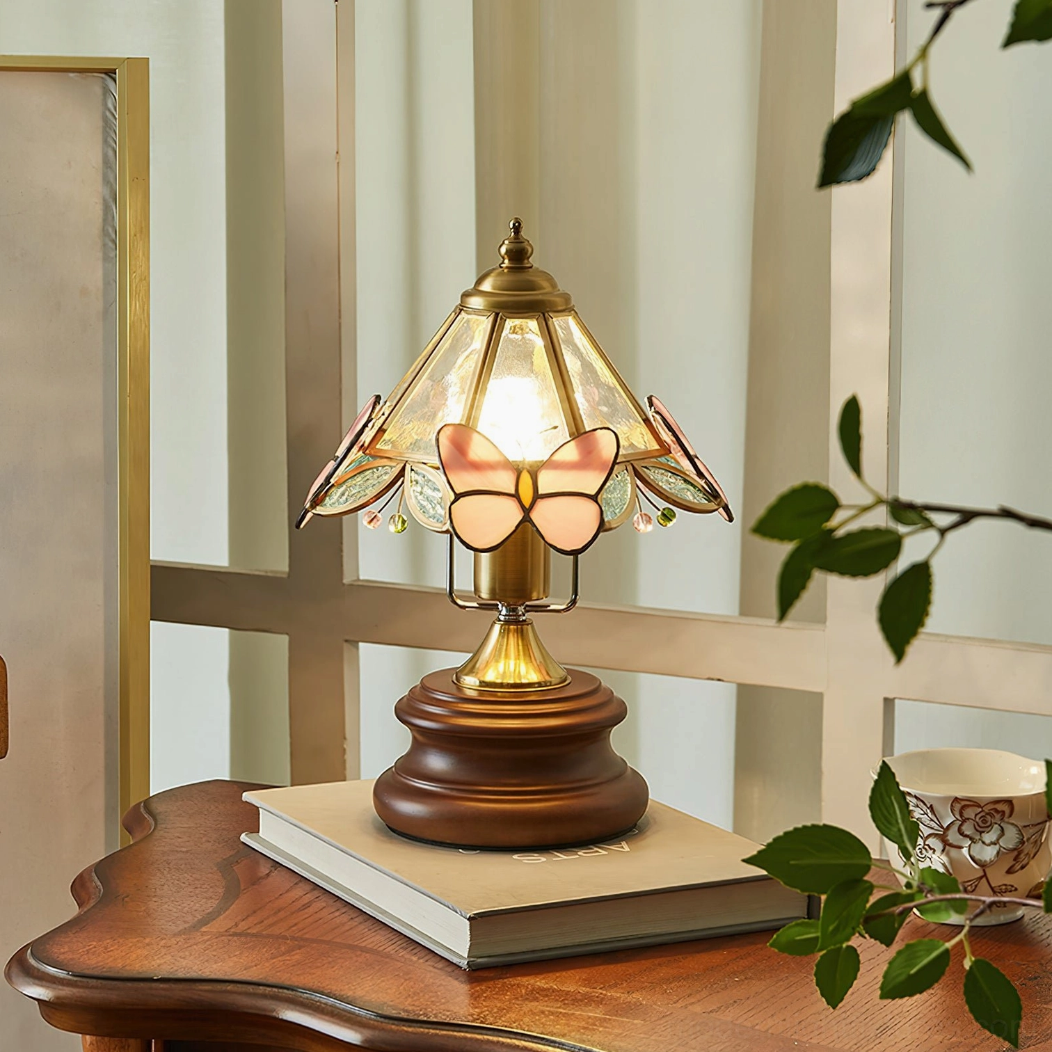 Stained glass butterfly table lamp overhead view showing pink glass shade detail on wooden surface