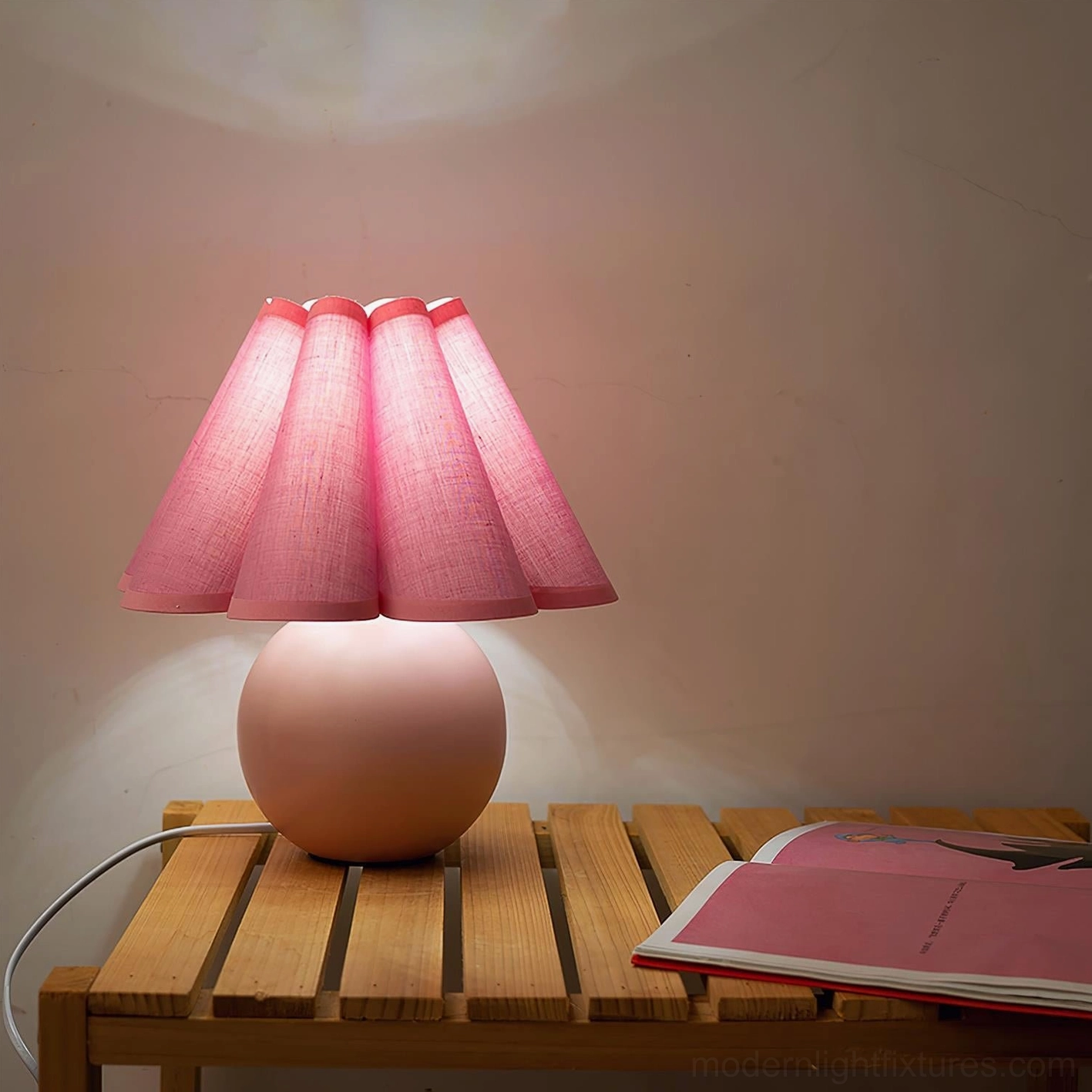 Pink pleated sunburst table lamp with ceramic base available in multiple color finishes for contemporary interiors
