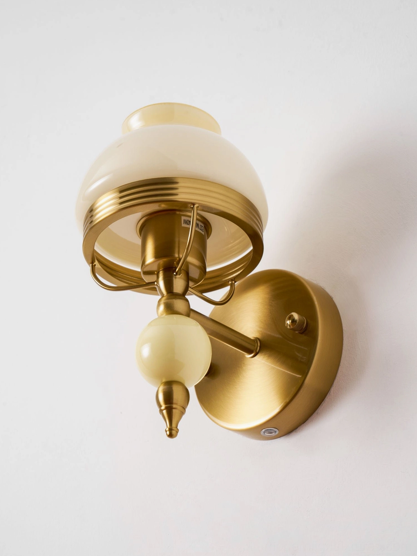 Pink vintage wall lamp featuring frosted glass with floral design and brass mounting fixture