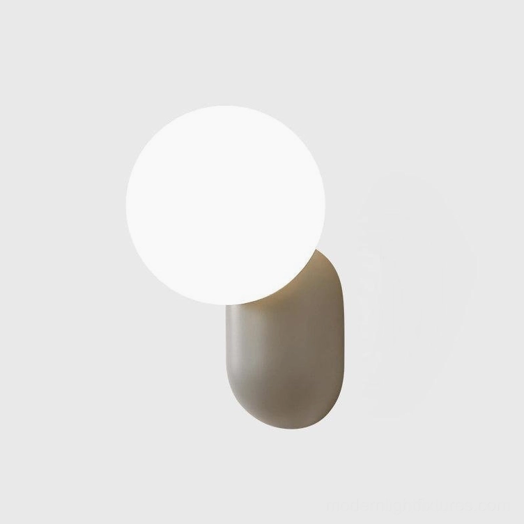 Pink finish spherical wall sconce adding playful contemporary accent to Scandinavian interior space