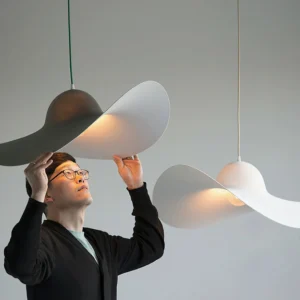 Two Piuma pendant lights in Nordic minimalist interior - white and gray resin pendant fixtures over dining area