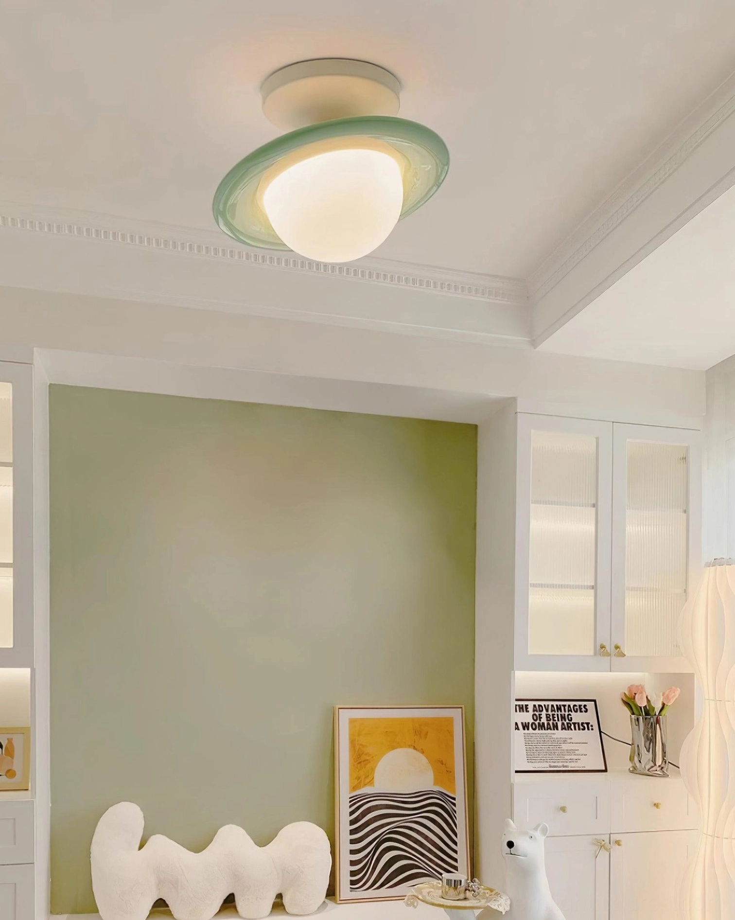 Mint green planet ceiling light installed above green accent wall in Nordic style living space
