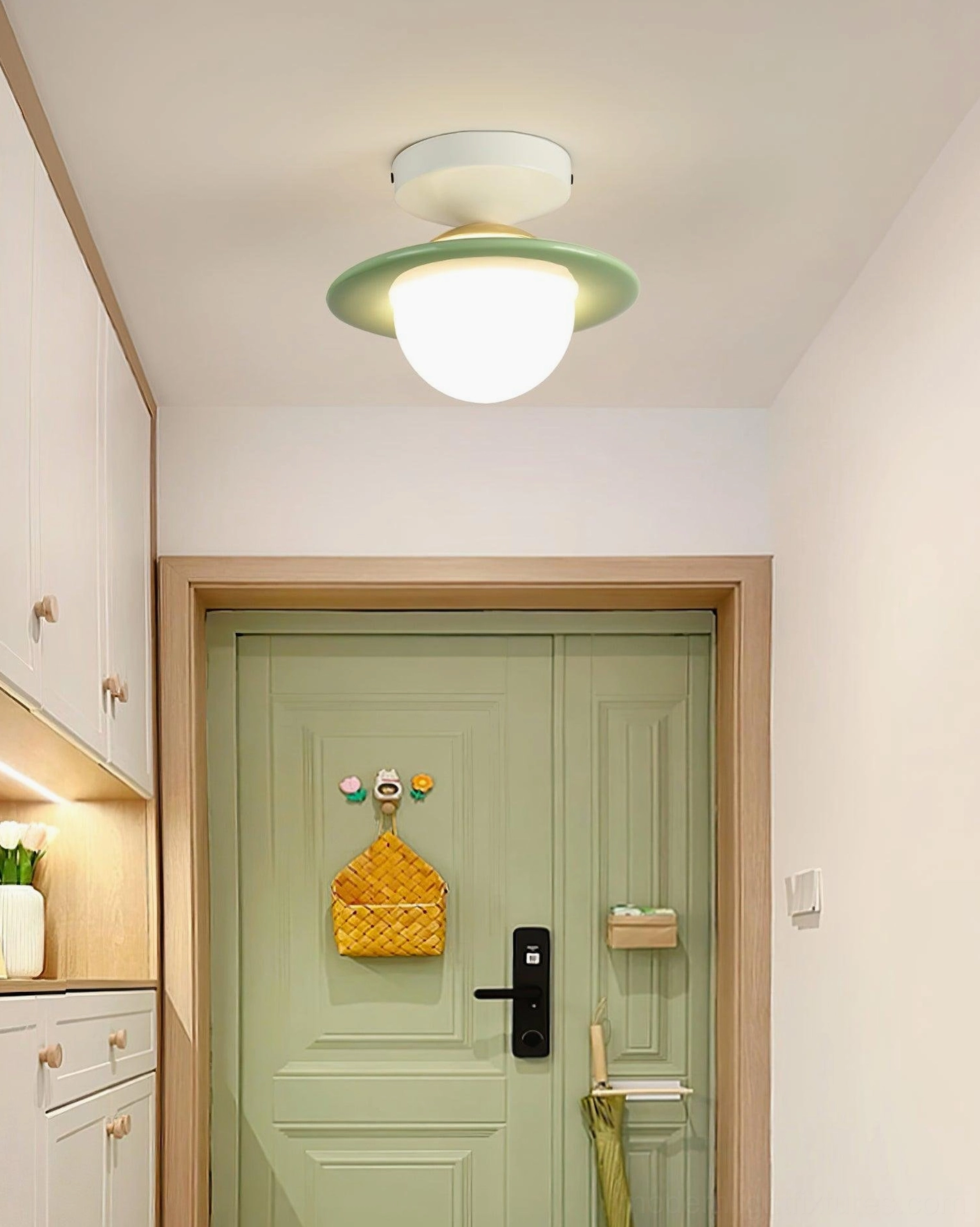 Mint green trim planet ceiling light installed in modern home entryway near green front door