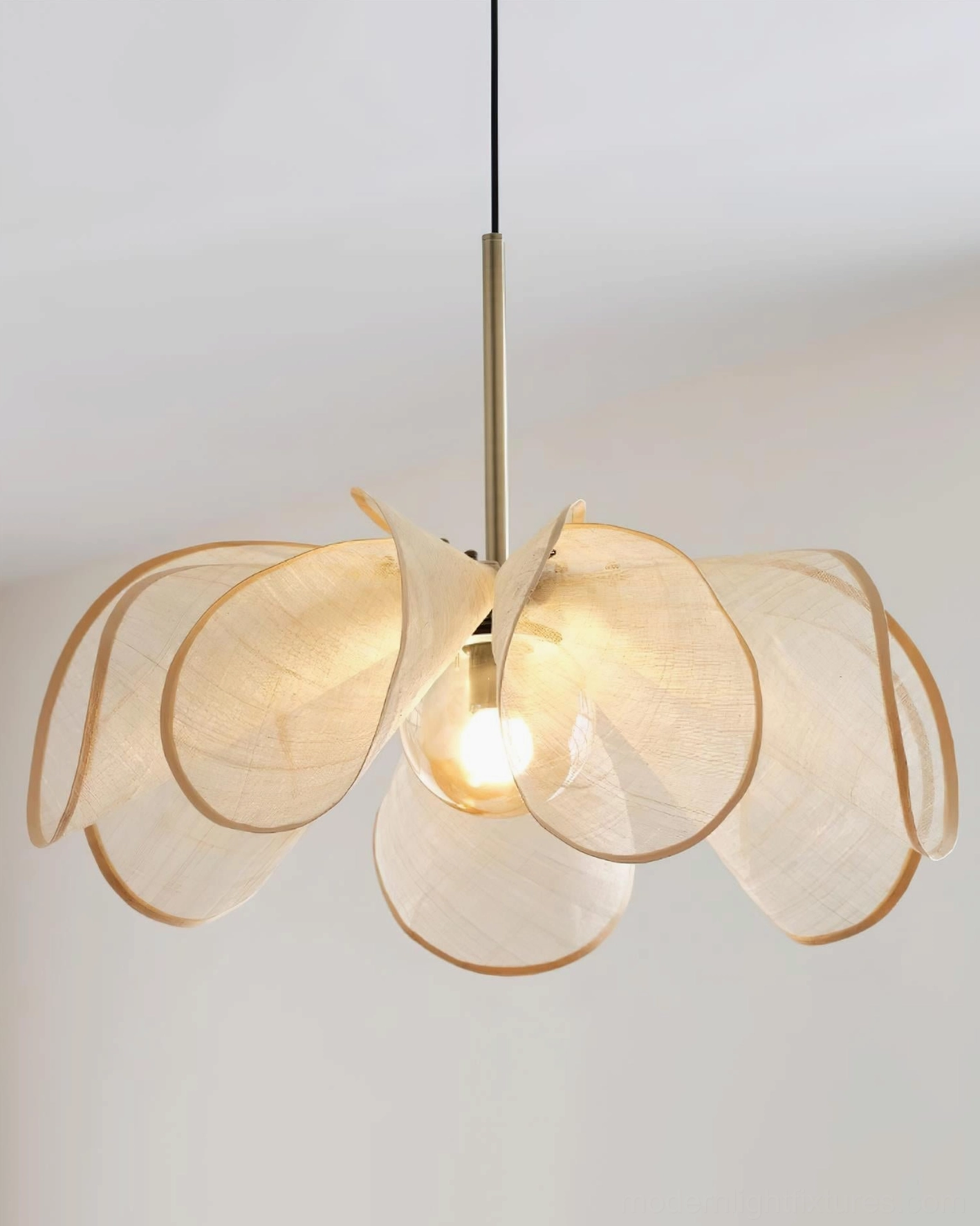 Natural plant fiber petal pendant lamp with warm glow creating soft ambient lighting in contemporary home setting