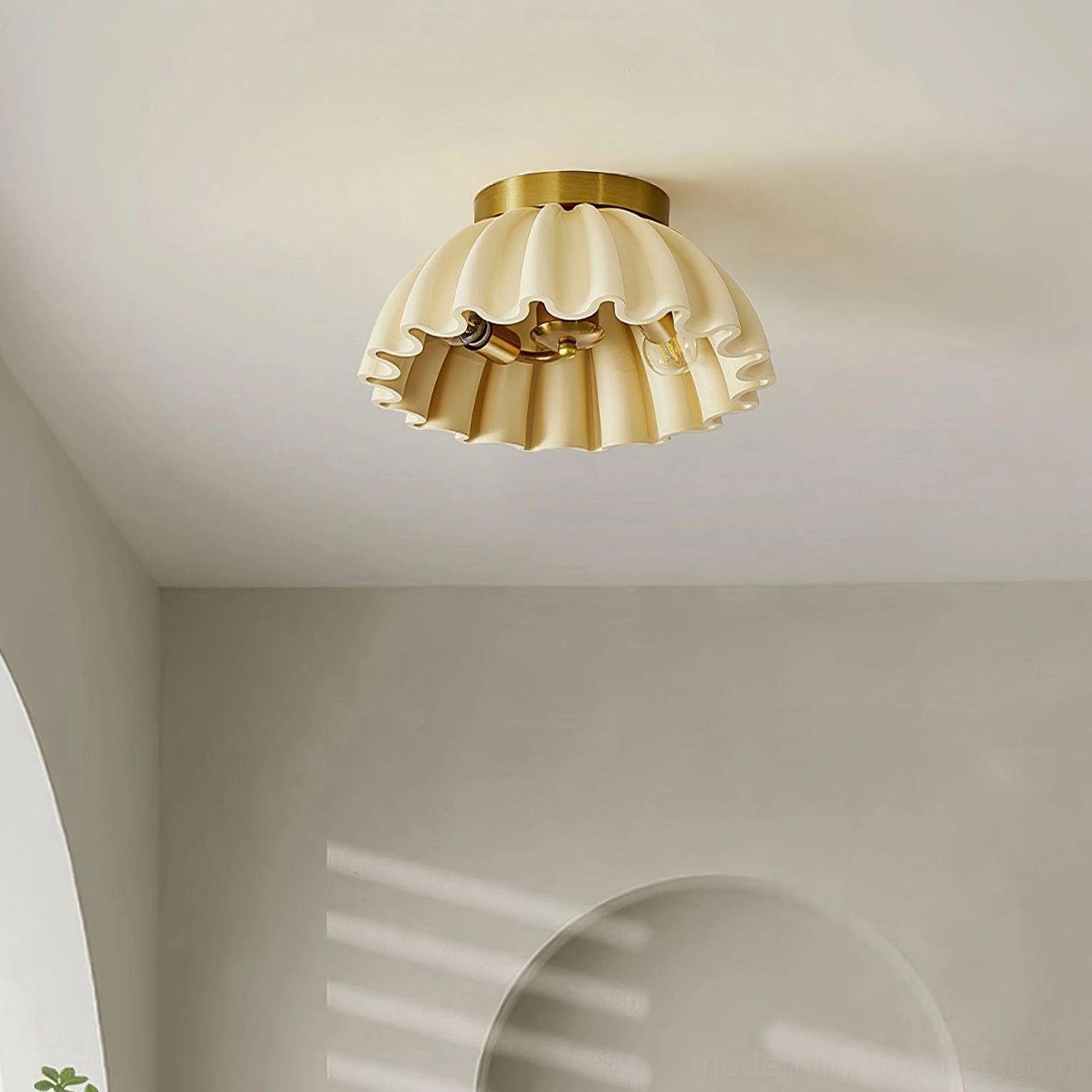 Close-up overhead angle of ruffled ceiling light fixture in minimalist room with striped wall detail
