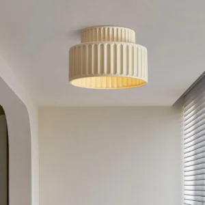 Modern pleated fabric ceiling light fixture with warm interior glow installed on white residential ceiling