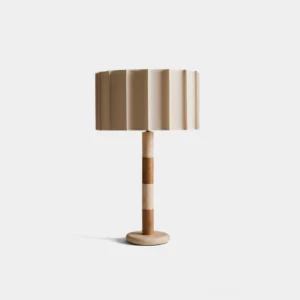 Pleated drum table lamp with beige fabric shade and color-blocked travertine and walnut wood base, front studio view