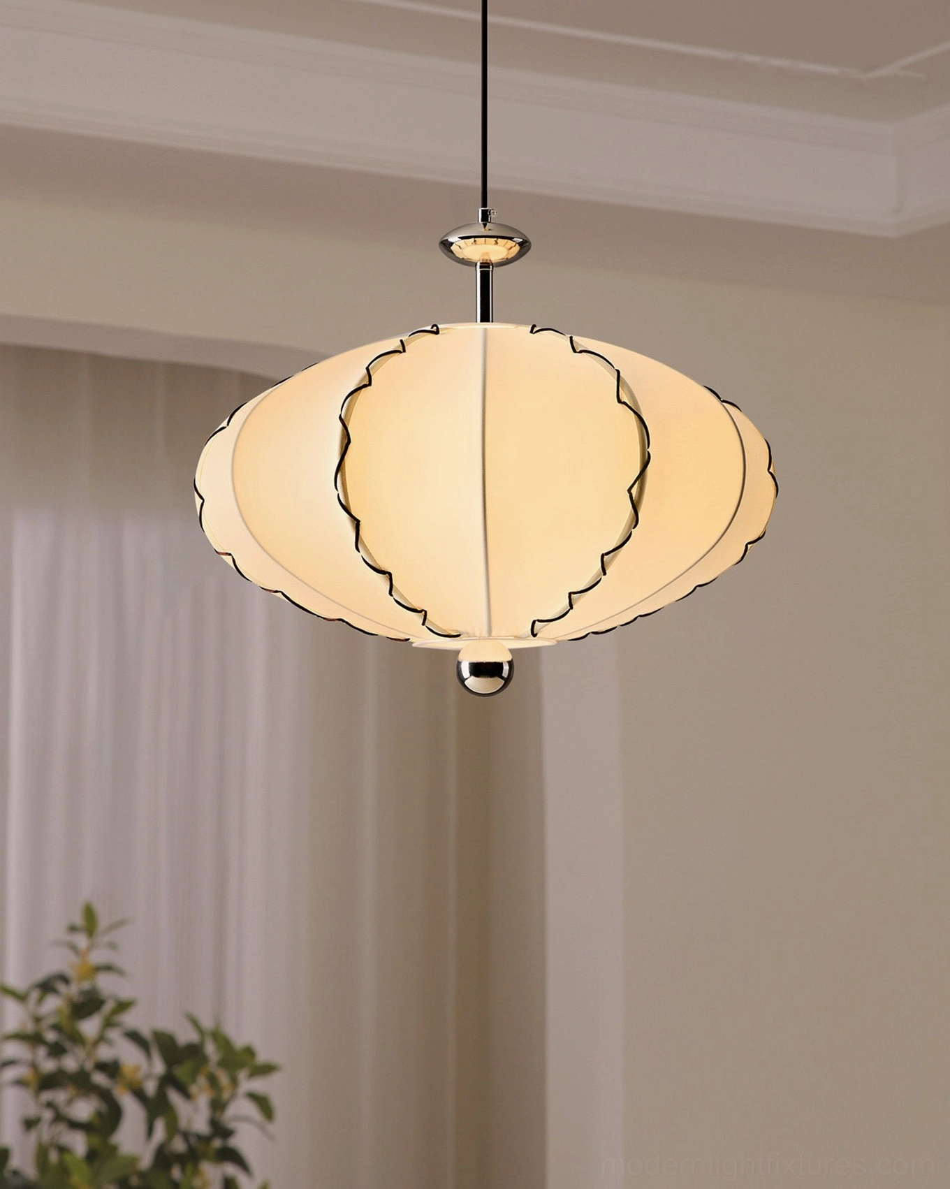 Close-up studio shot of cream pleated fabric shade with black scalloped trim edges and polished chrome suspension hardware