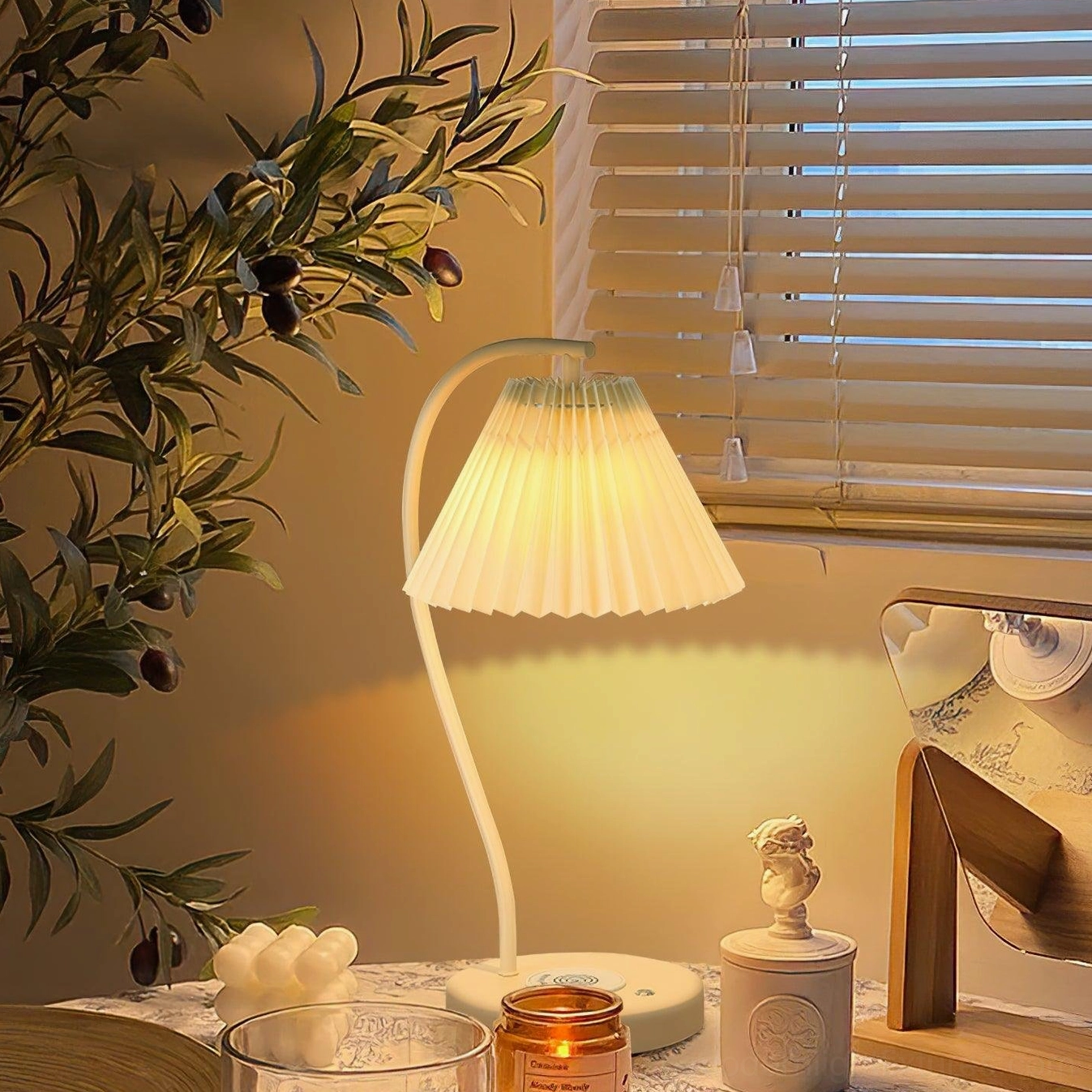 Pleated table lamp with fabric shade creating ambient light with plant décor