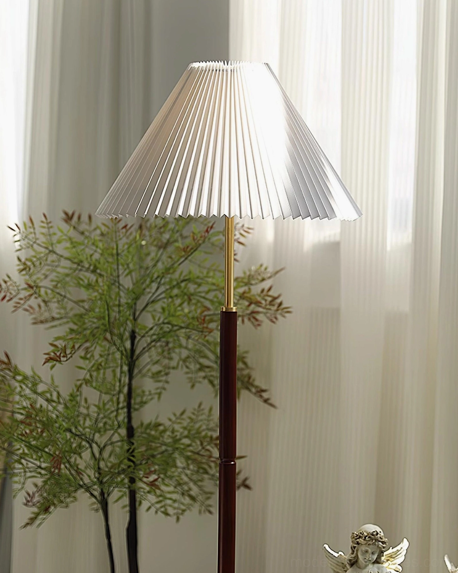Modern pleated floor lamp beside window with brown metal base and potted plant