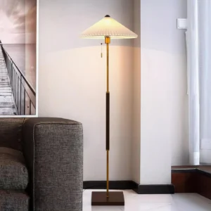 Modern pleated shade floor lamp in minimalist living room with grey sofa and warm ambient lighting