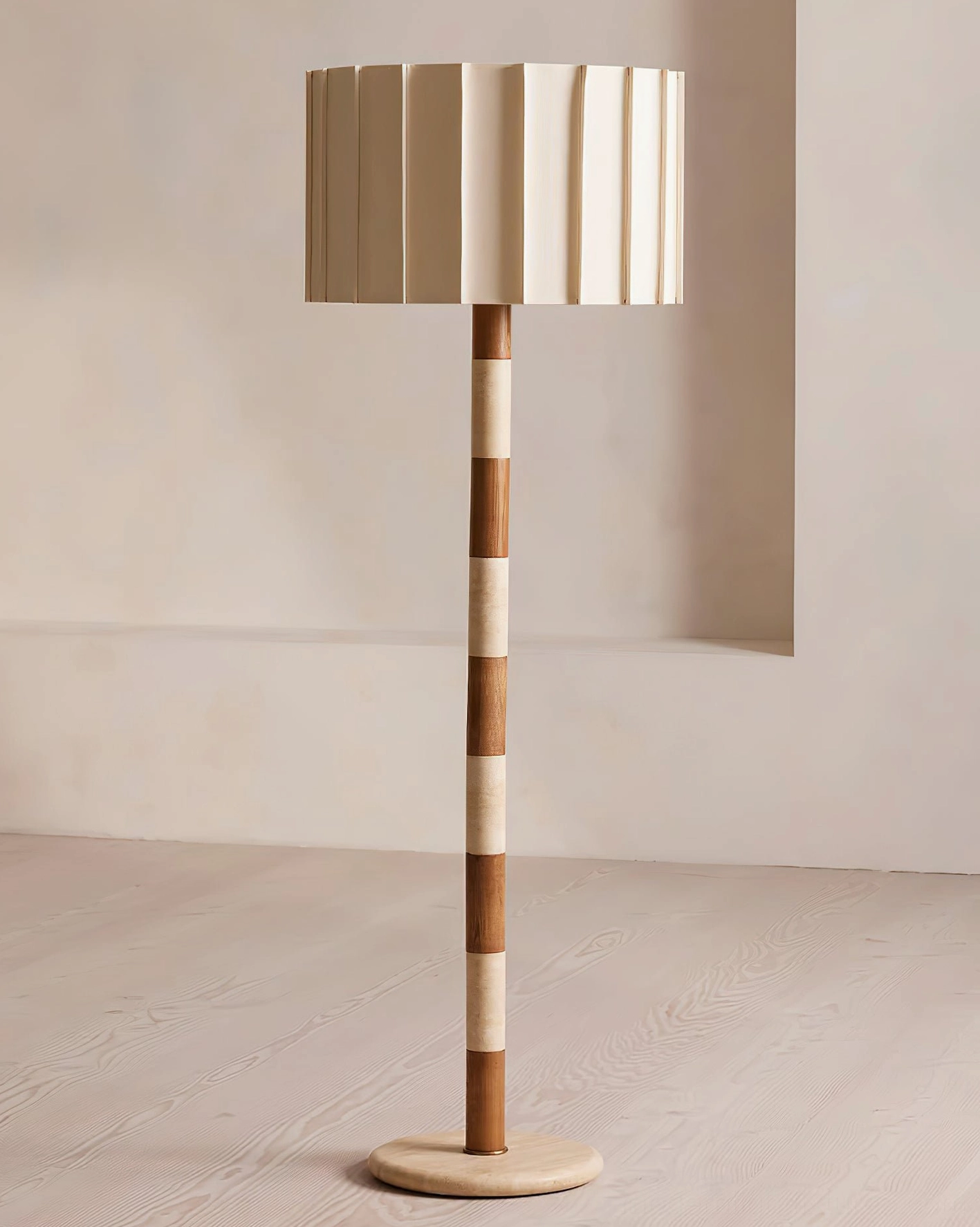 Pleated grove floor lamp positioned in contemporary space emphasizing the vertical architectural statement and two-tone material composition