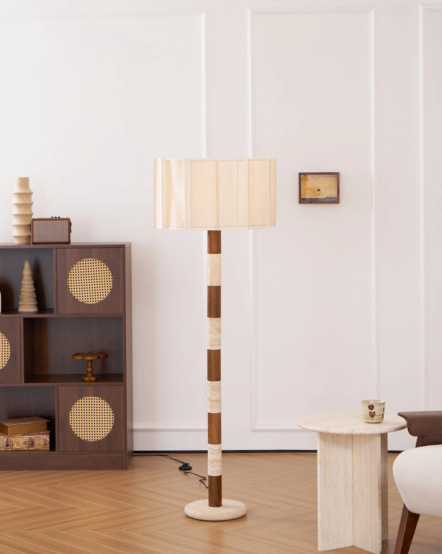 Pleated grove floor lamp side view in bright minimalist interior beside dark woven storage cabinet, neutral earth tone color scheme