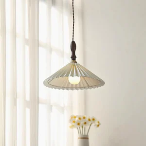 Modern pleated fabric pendant lamp with exposed bulb and twisted cord in warm farmhouse bedroom interior with window curtains