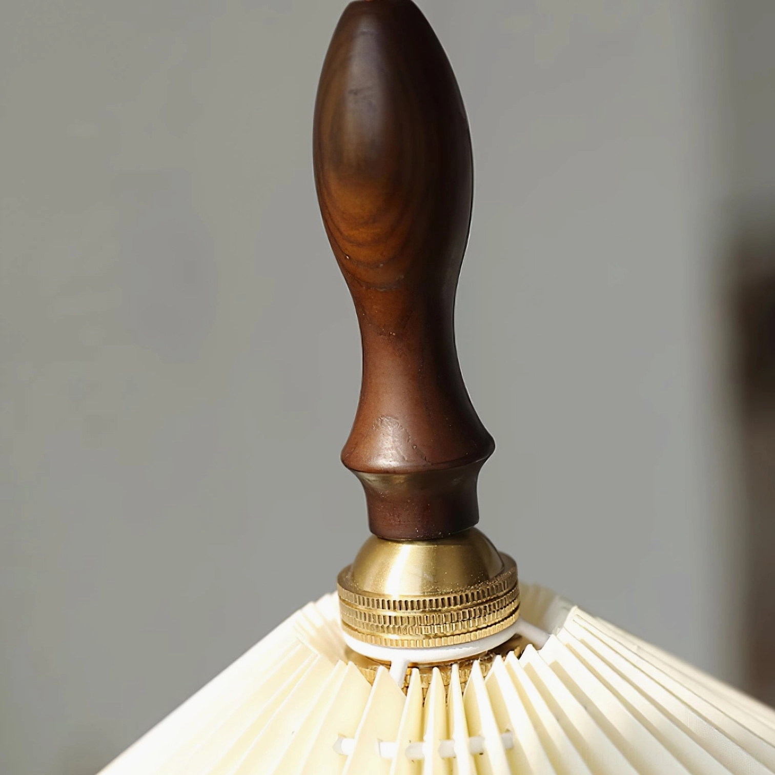 Pleated pendant light in dining room accent installation with warm walnut wood tone complement