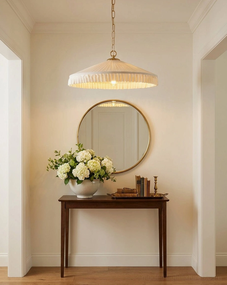 Pleated pendant light in farmhouse entryway with round mirror and floral table centerpiece