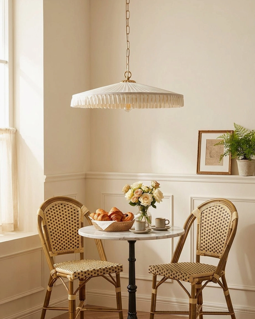 Vintage pleated pendant light over round marble table with rattan dining chairs, French country style