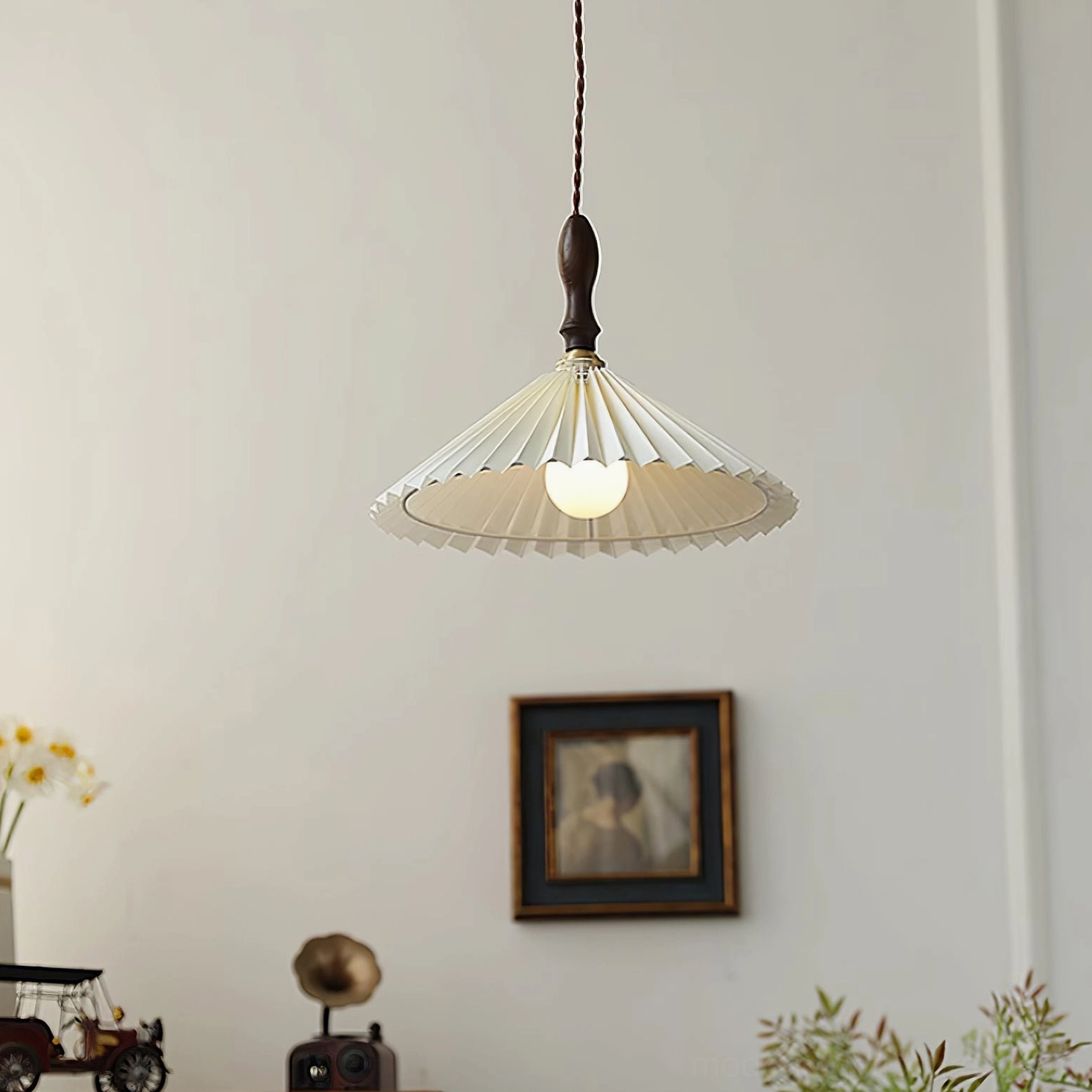 Illuminated pleated pendant light with warm glow from walnut wood frame in vintage interior