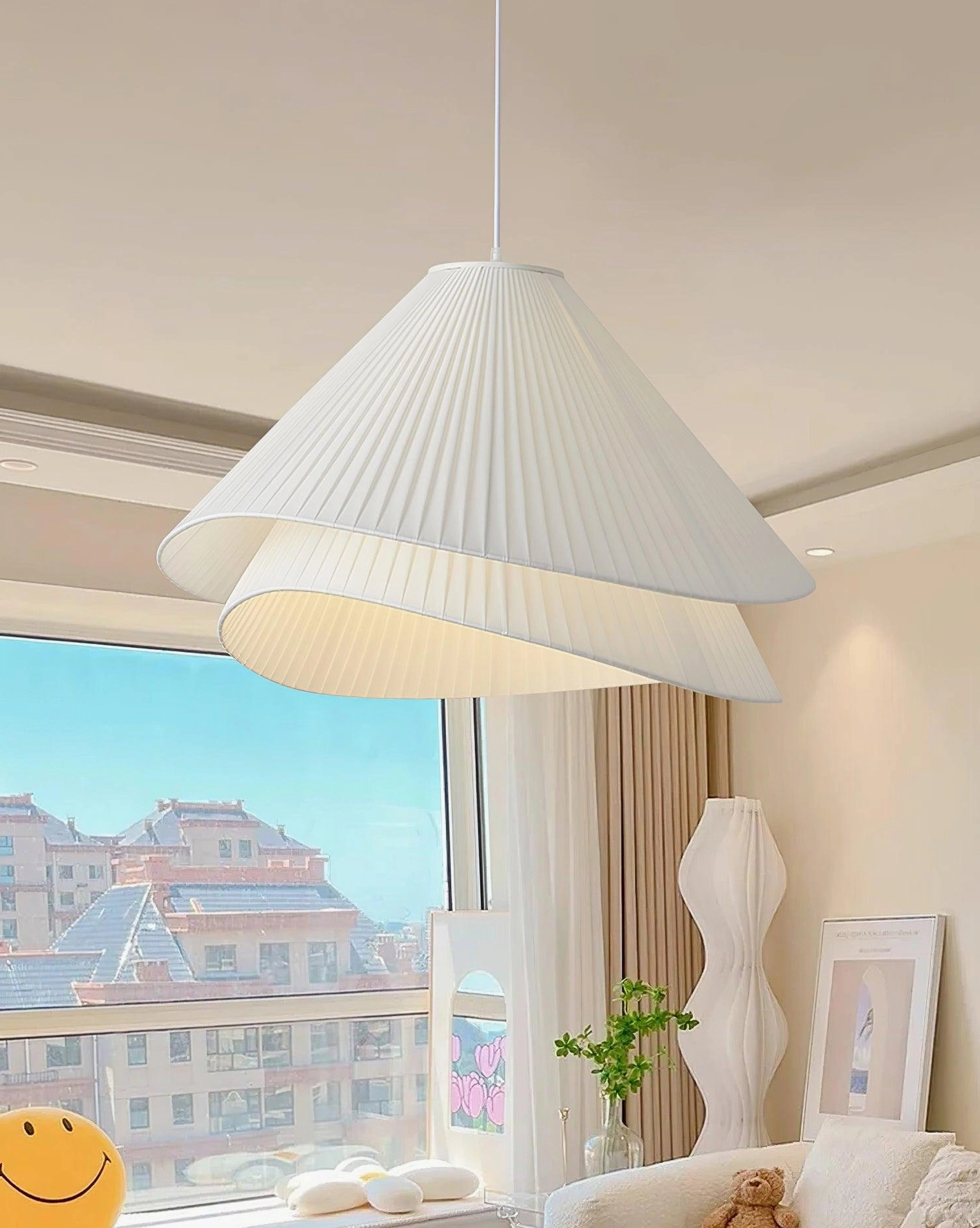 Modern pleated pendant light installed over living room coffee table with floor-to-ceiling city views