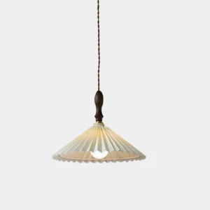 Pleated fabric pendant light with walnut wood hardware and off-white linen shade shown in minimalist studio setting