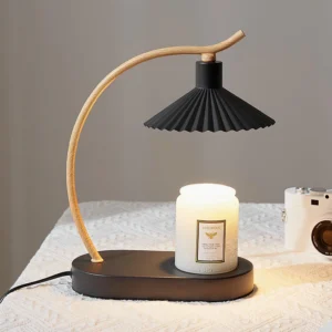 Contemporary pleated table lamp in bedroom setting on bedside table with scented candle