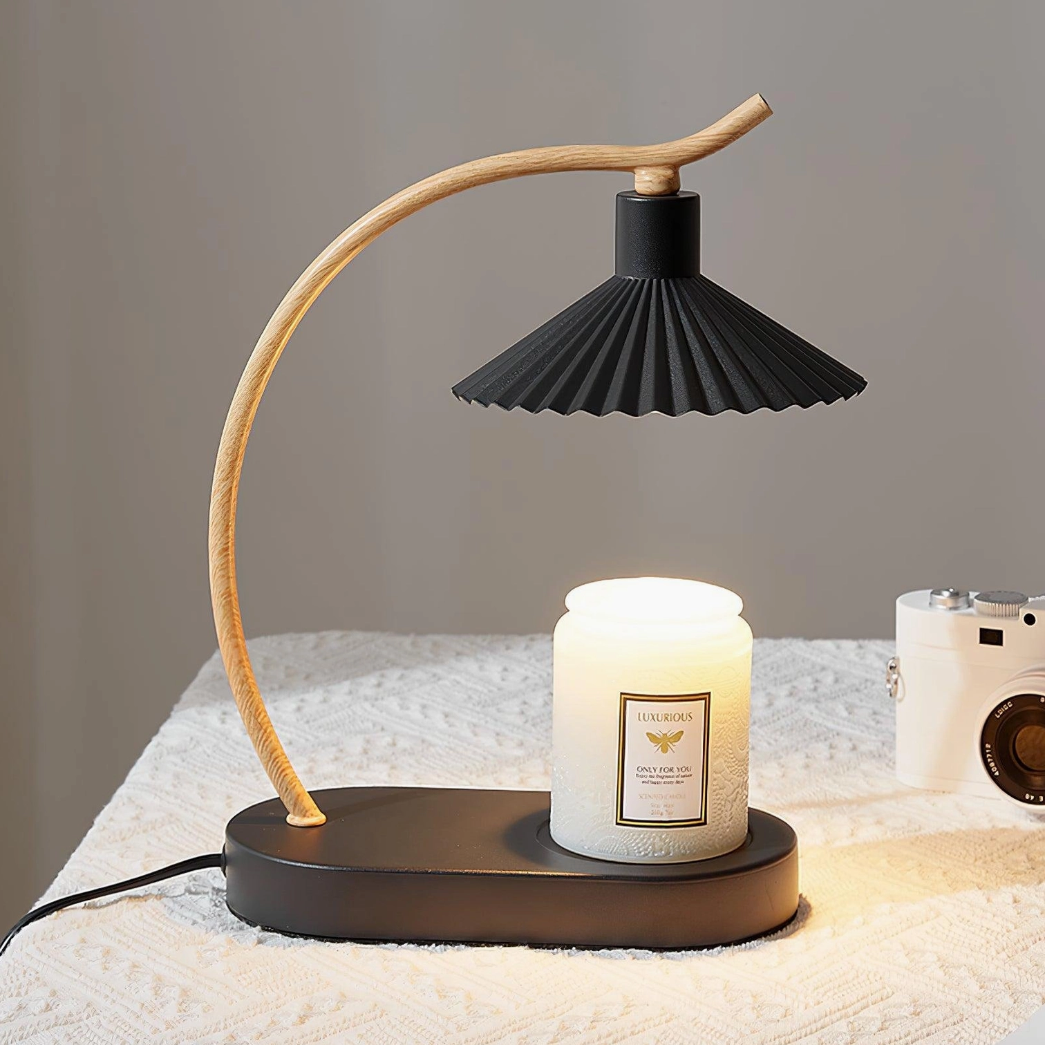 Contemporary pleated table lamp in bedroom setting on bedside table with scented candle