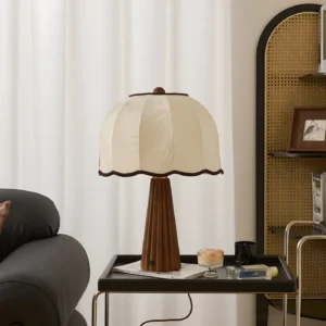 Modern vintage table lamp with pleated wood base on side table next to leather sofa - warm ambient lighting