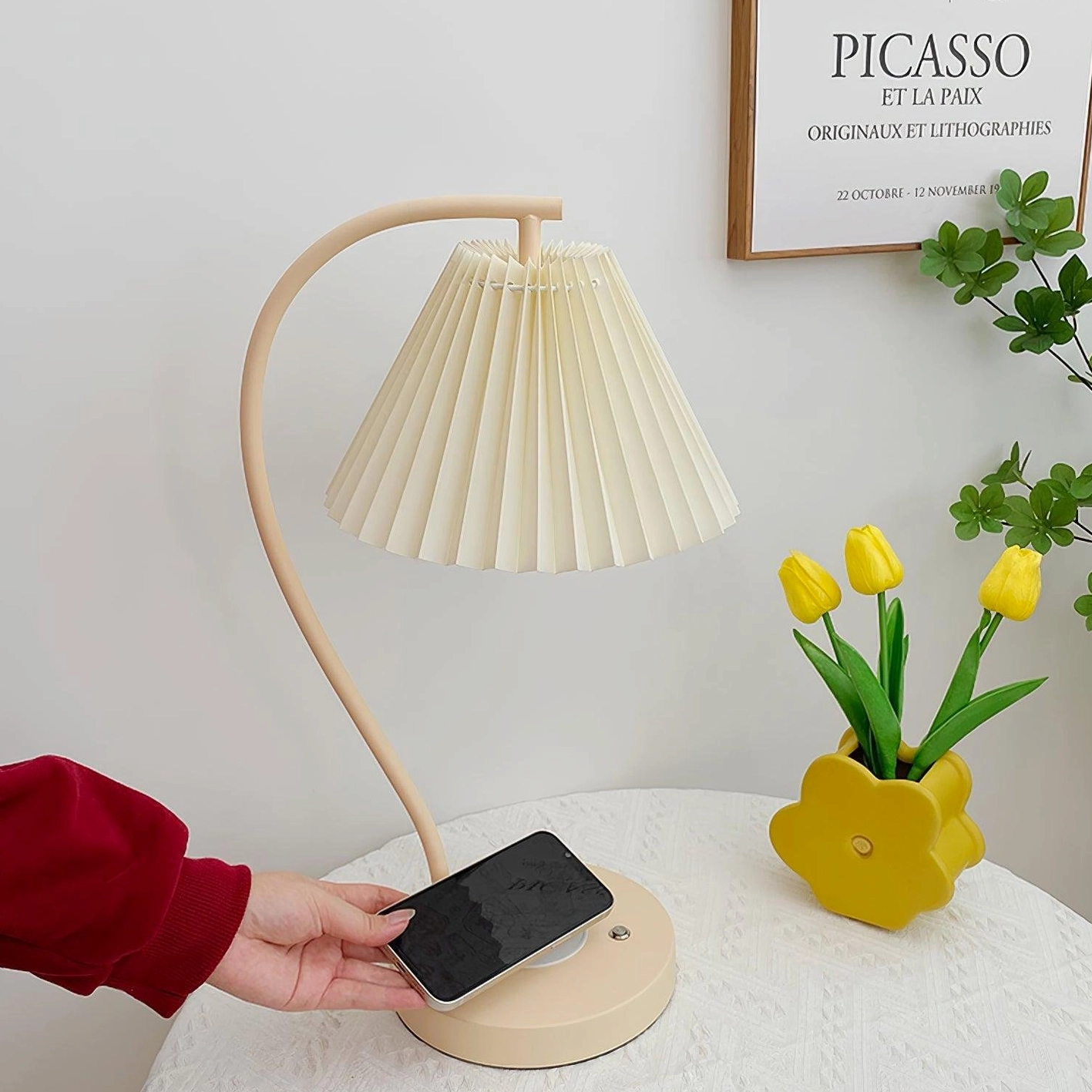 Modern desk lamp with pleated fabric shade and USB charging port demonstration