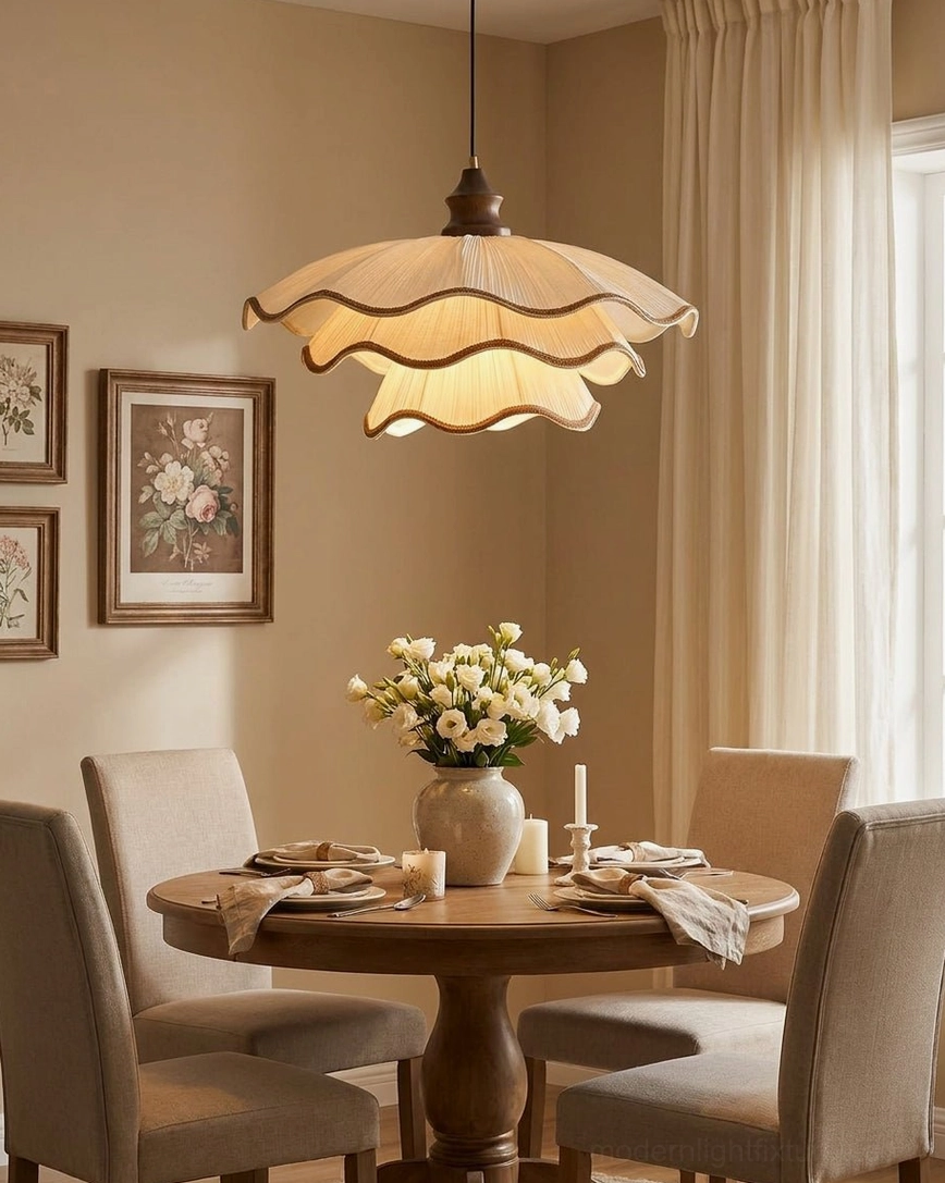 Pliora pleated fabric pendant light hanging above formal dining table with upholstered chairs and floral centerpiece