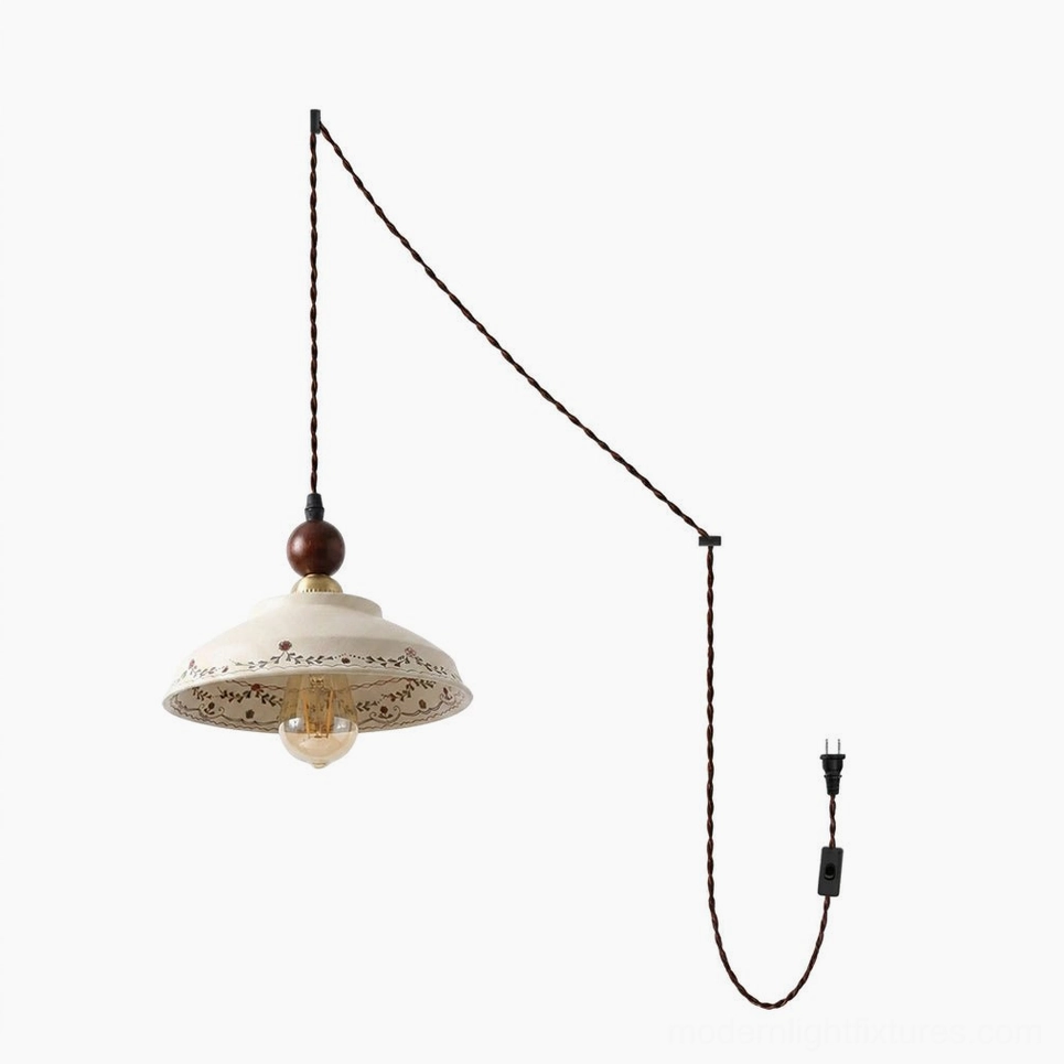 Hand-painted ceramic plug-in pendant light studio view showing braided brown power cord, inline on-off switch, standard polarized plug, and cream stoneware construction