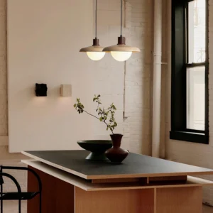 Matching pendant lights in loft-style dining kitchen with exposed brick and warm ambient lighting