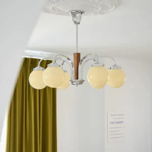Polaris Bauhaus chandelier illuminated overhead view in living room with green velvet curtains warm ambient lighting