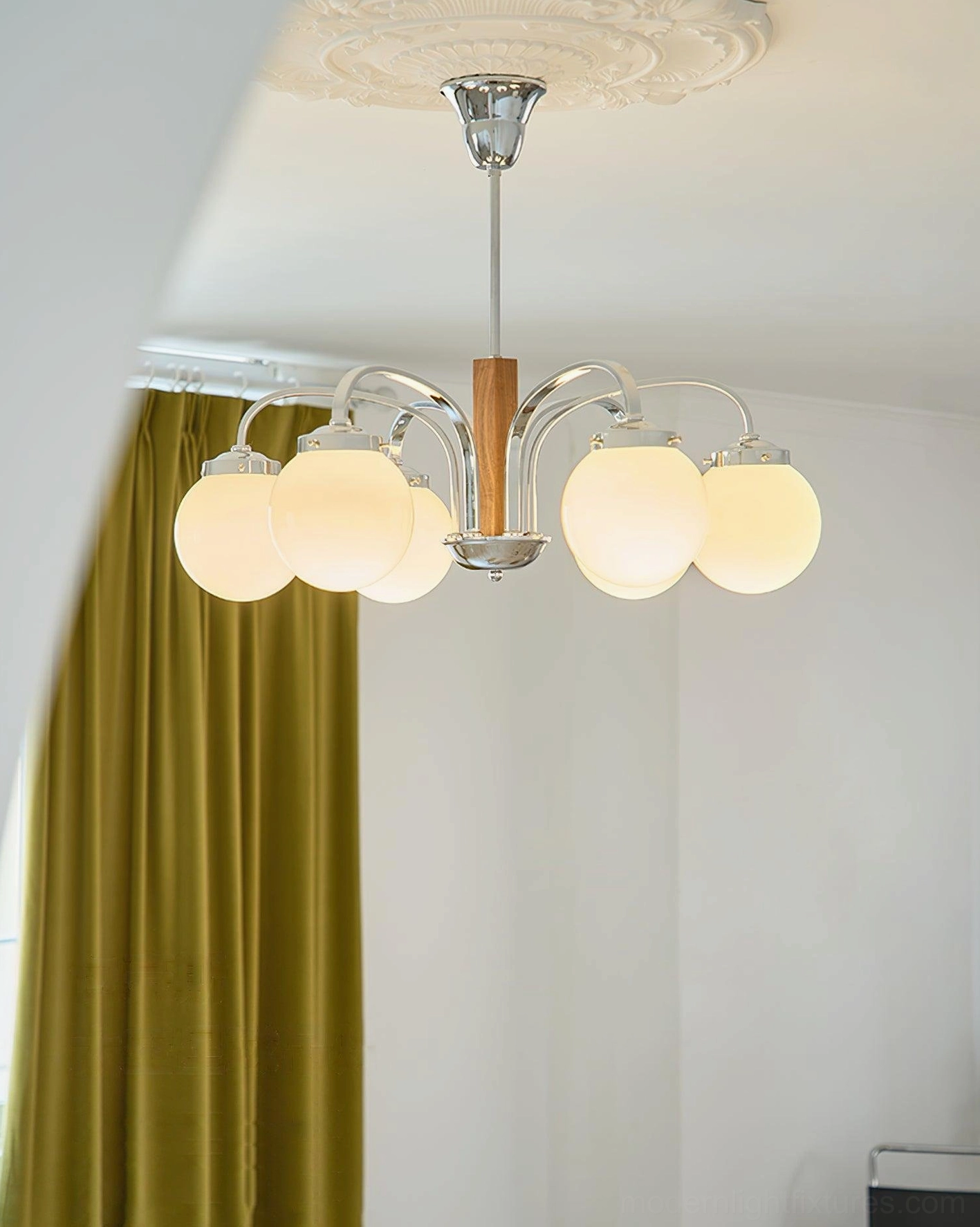 Polaris mid-century modern chandelier side view illuminated warm lighting green velvet contemporary interior