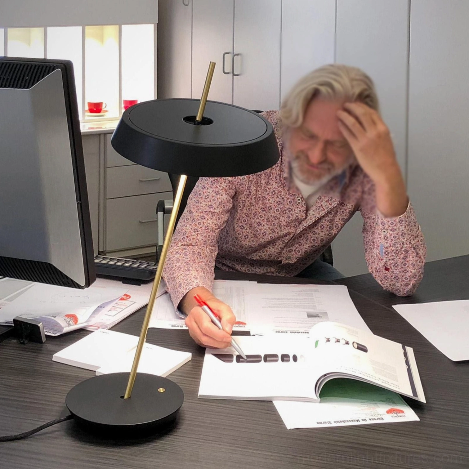 Black Poldina modern table lamp in minimalist home office with computer and work desk accessories
