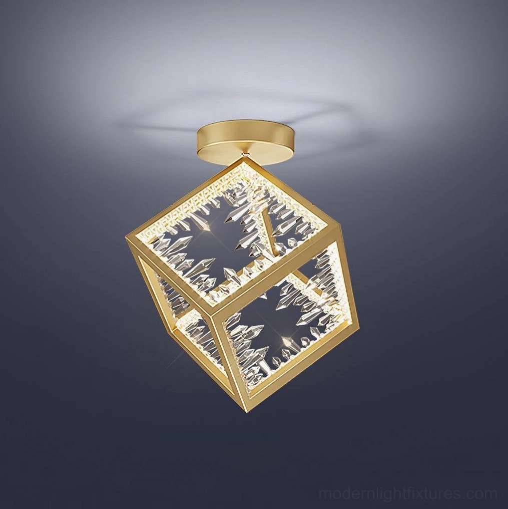 Close-up overhead shot of polished brass cubic ceiling light with intricate carved glass