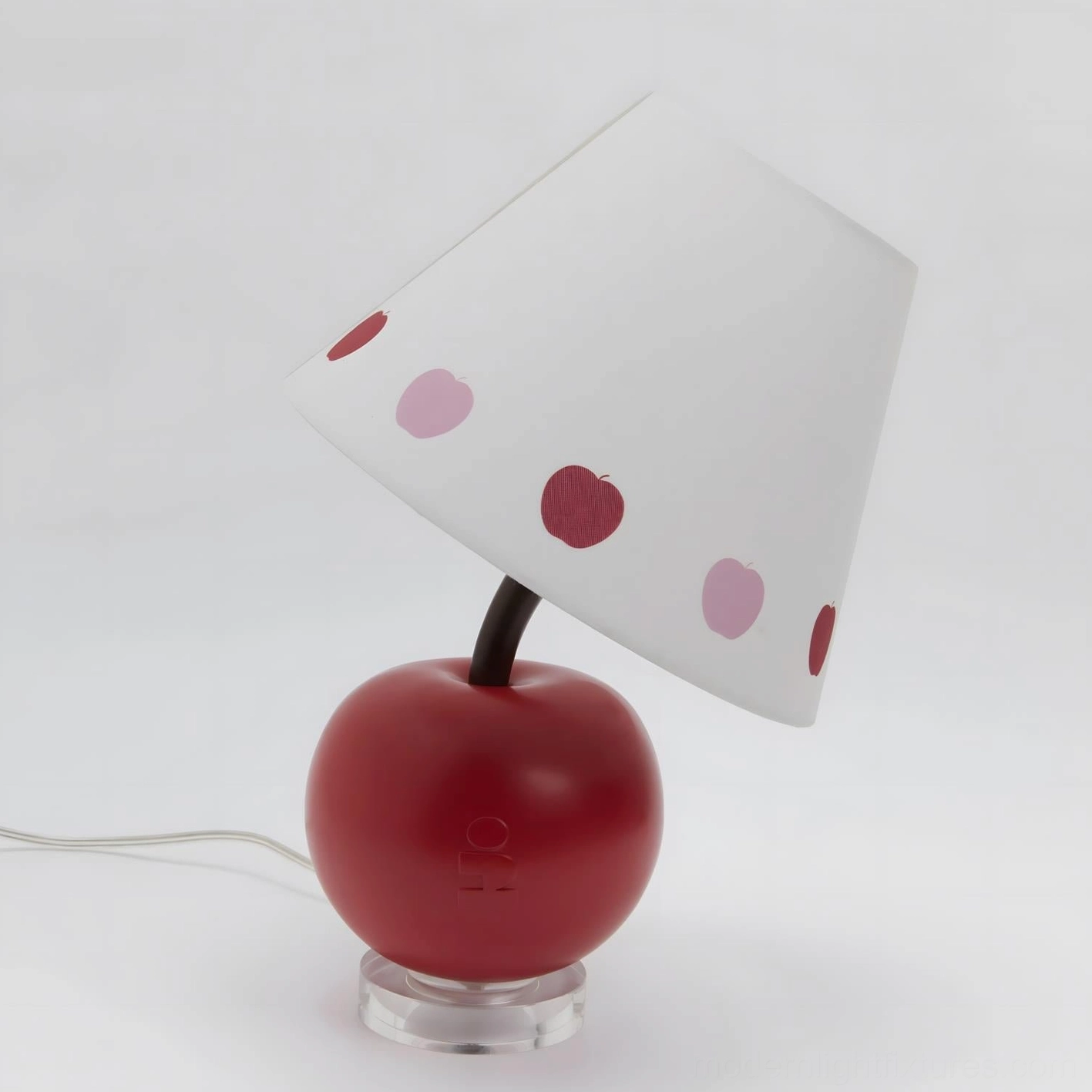 Pop art red apple-shaped table lamp with white polka-dot shade, playful modern design studio view